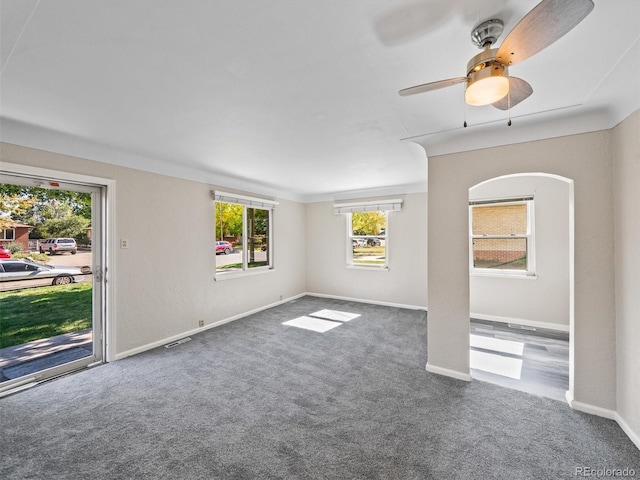 empty room featuring baseboards, visible vents, ceiling fan, and carpet floors