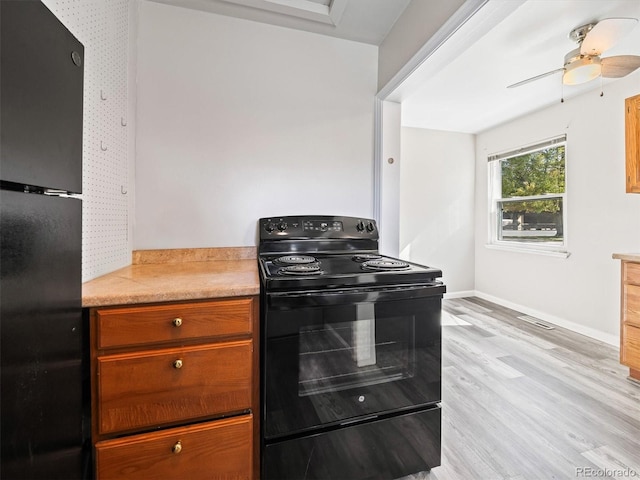 kitchen with baseboards, visible vents, black appliances, light countertops, and light wood-type flooring