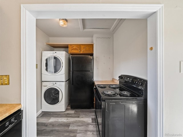 clothes washing area with laundry area, light wood finished floors, attic access, and stacked washer and clothes dryer