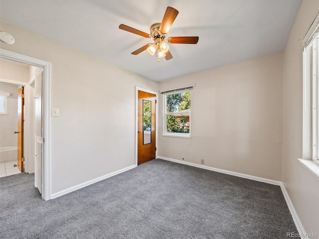 empty room featuring carpet flooring, baseboards, and a ceiling fan
