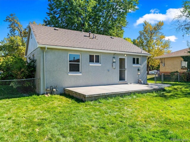 back of house featuring fence, a yard, a patio, stucco siding, and a shingled roof