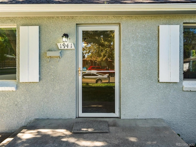 entrance to property featuring stucco siding