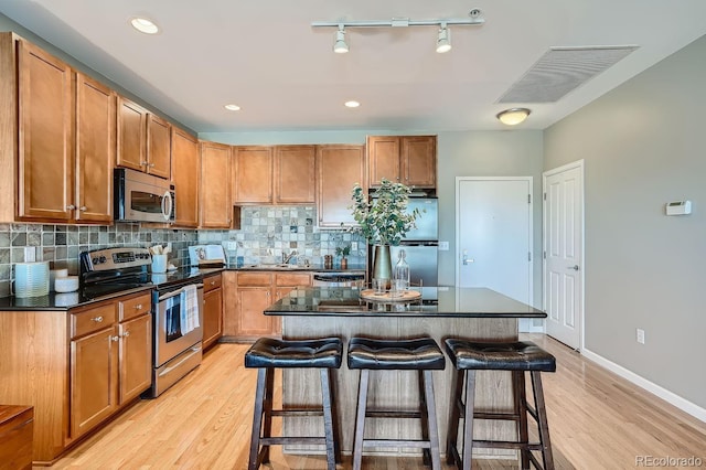 kitchen featuring stainless steel appliances, tasteful backsplash, a center island, and a kitchen breakfast bar