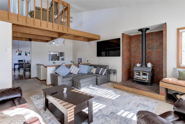 living room featuring a wood stove and high vaulted ceiling