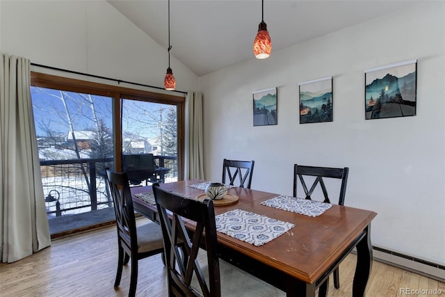 dining space featuring a baseboard radiator, light hardwood / wood-style flooring, and lofted ceiling