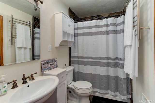 bathroom featuring a shower with shower curtain, toilet, and sink