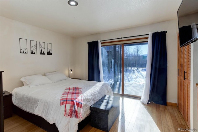 bedroom with access to outside and light hardwood / wood-style flooring