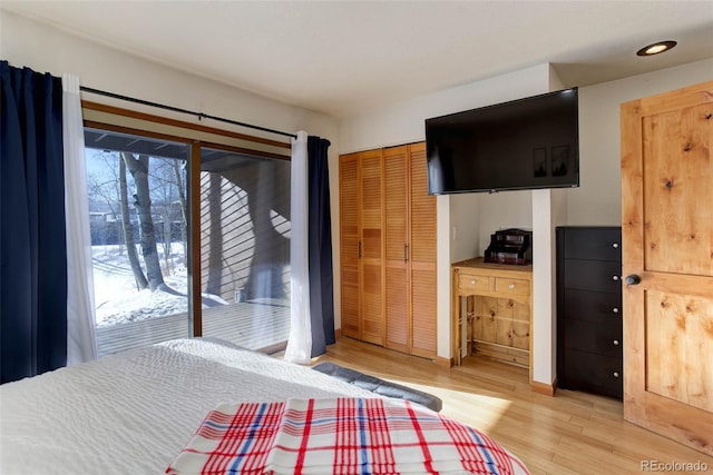 unfurnished bedroom with access to exterior, a closet, multiple windows, and hardwood / wood-style flooring