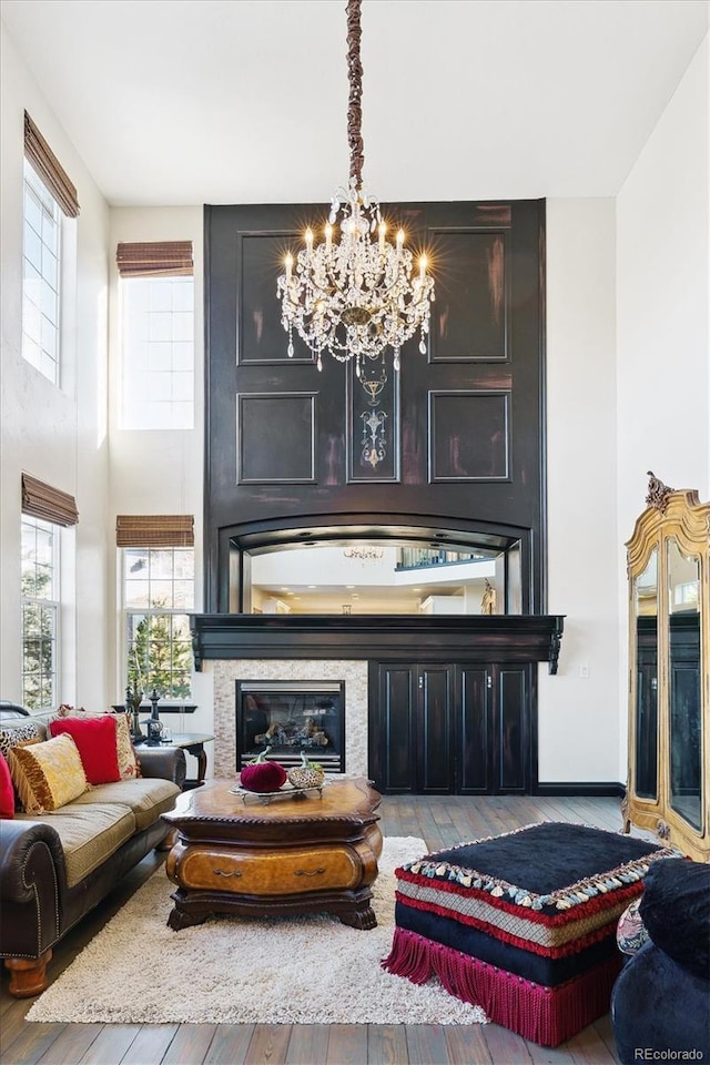 interior space featuring a fireplace, light hardwood / wood-style flooring, and an inviting chandelier