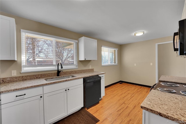 kitchen with sink, white cabinetry, light stone counters, light wood-type flooring, and black appliances