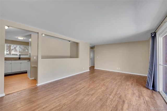 spare room featuring sink and light hardwood / wood-style floors