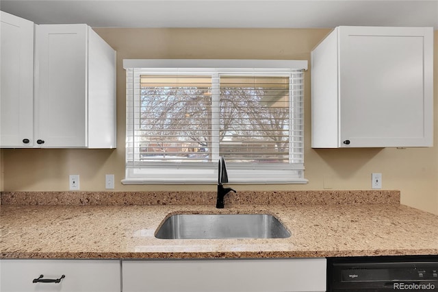 kitchen featuring dishwasher, light stone countertops, sink, and white cabinets