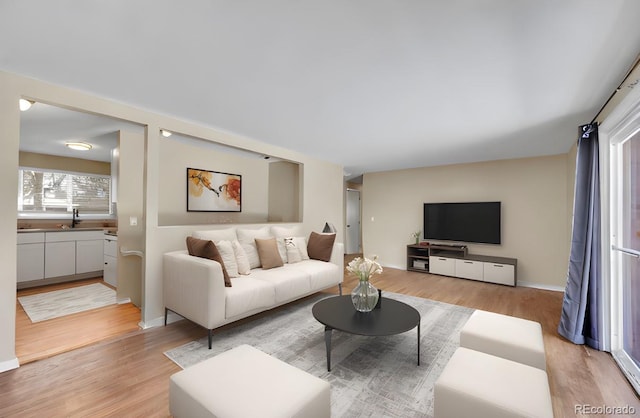 living room with light hardwood / wood-style floors and sink