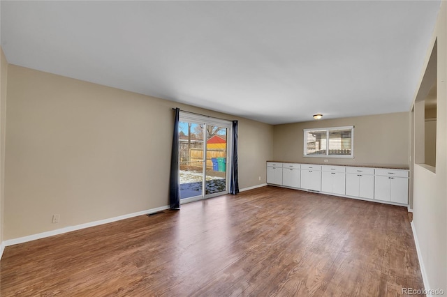 unfurnished living room featuring plenty of natural light and wood-type flooring