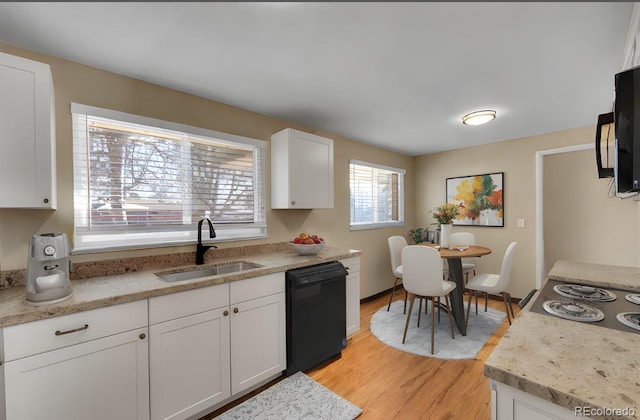 kitchen featuring white cabinetry, sink, light hardwood / wood-style flooring, and black dishwasher