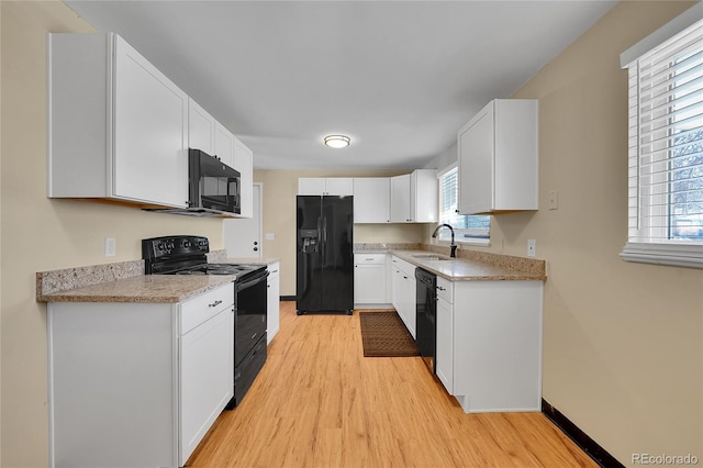 kitchen with white cabinetry, sink, light wood-type flooring, and black appliances