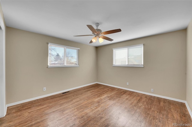 unfurnished room with hardwood / wood-style flooring, plenty of natural light, and ceiling fan