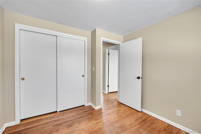 unfurnished bedroom with a closet and light wood-type flooring