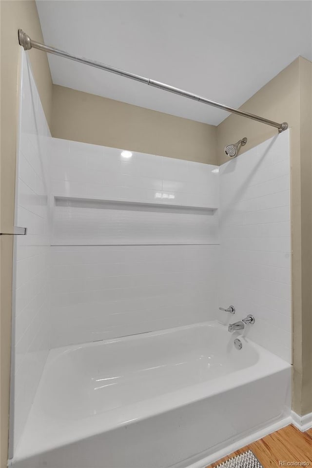 bathroom with shower / bath combination and hardwood / wood-style floors