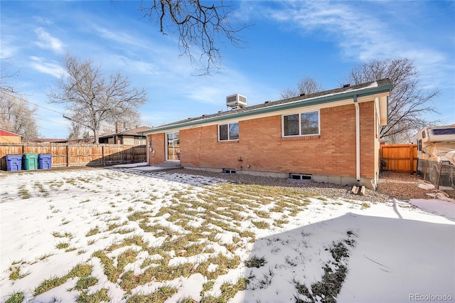 snow covered rear of property with cooling unit