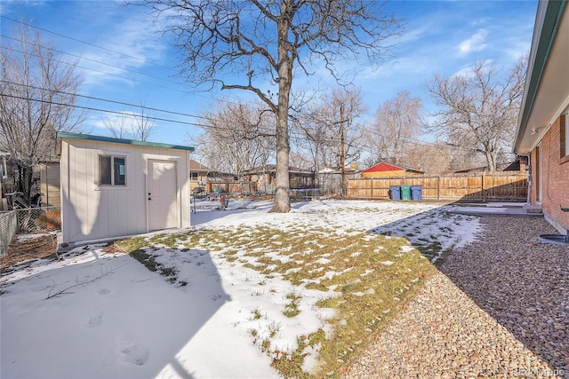 yard layered in snow featuring a storage shed