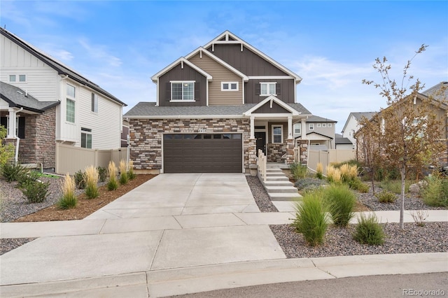 craftsman house with a garage, driveway, board and batten siding, and fence