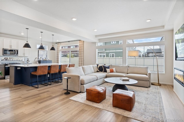 living room featuring recessed lighting, light wood-style flooring, and baseboards