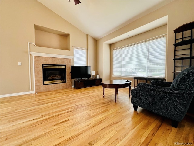 6188 Viewpoint Ave, Firestone, CO 80504 - living room featuring wood finished floors, lofted ceiling, a tiled fireplace, baseboards, and ceiling fan