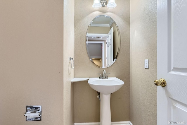 bathroom with ornamental molding and sink