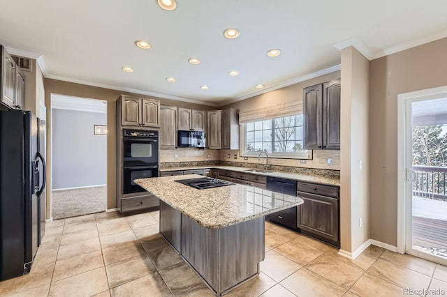 kitchen with light stone countertops, a center island, sink, light tile patterned floors, and black appliances