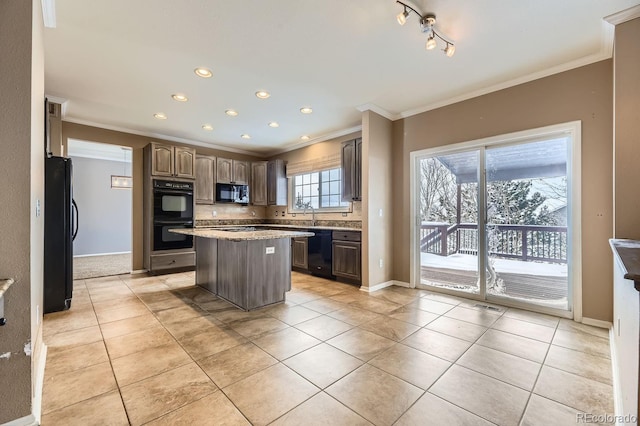 kitchen with light tile patterned flooring, crown molding, a kitchen island, and black appliances