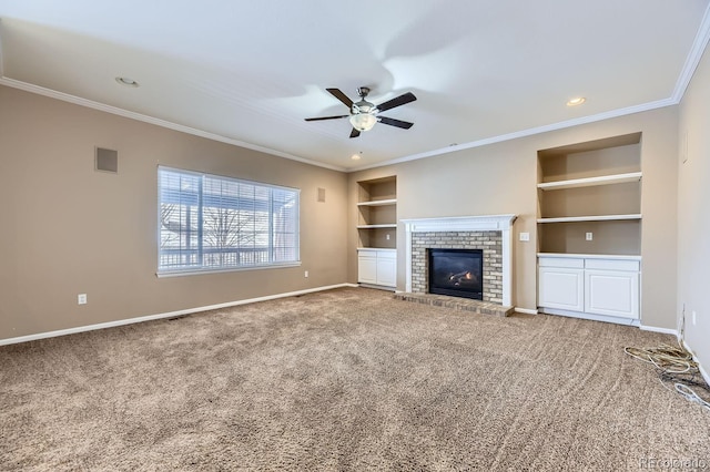 unfurnished living room with ceiling fan, a brick fireplace, built in features, crown molding, and carpet floors