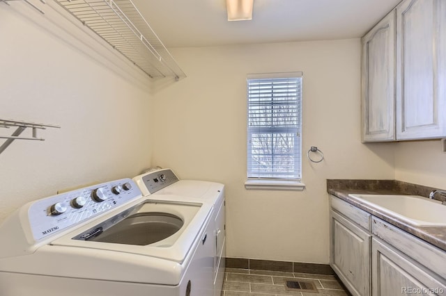 washroom with cabinets, independent washer and dryer, and sink