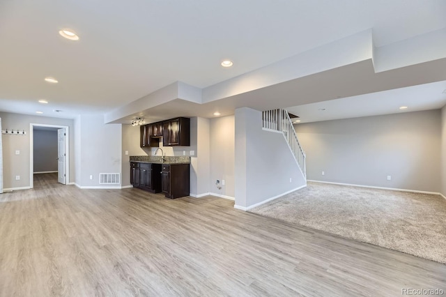 unfurnished living room with sink and light hardwood / wood-style flooring