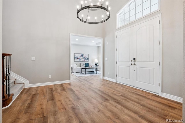 11911 E Lake Cir, Greenwood Village, CO 80111 - foyer entrance featuring a chandelier, a towering ceiling, wood finished floors, and stairs
