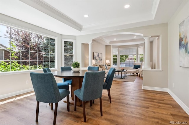 11911 E Lake Cir, Greenwood Village, CO 80111 - dining space with decorative columns, a tray ceiling, arched walkways, wood finished floors, and recessed lighting