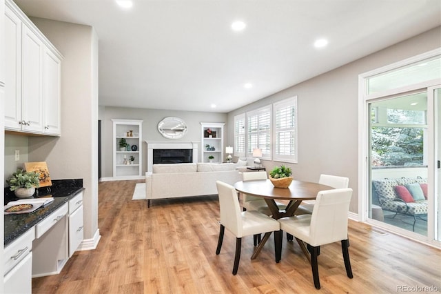 11911 E Lake Cir, Greenwood Village, CO 80111 - dining room with light wood-style flooring, built in features, a fireplace, and recessed lighting
