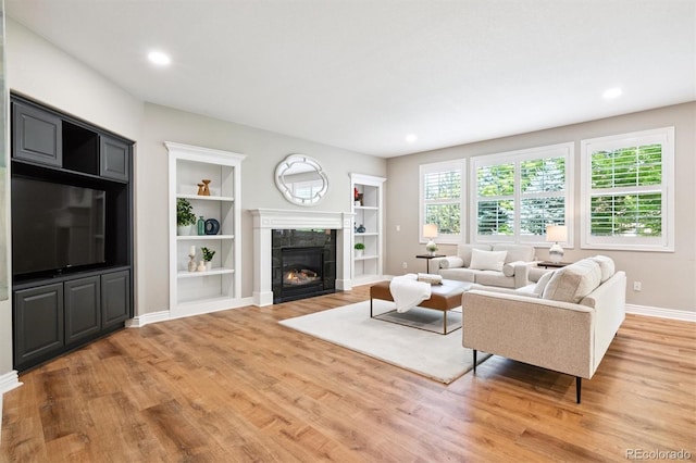 11911 E Lake Cir, Greenwood Village, CO 80111 - living room featuring a tiled fireplace, light wood-style floors, built in shelves, and recessed lighting
