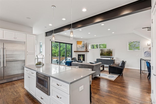 1373 S Garfield St, Denver, CO 80210 - kitchen with built in appliances, white cabinetry, dark wood-style flooring, hanging light fixtures, and a kitchen island