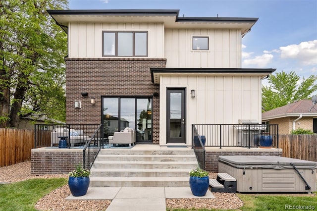 1373 S Garfield St, Denver, CO 80210 - back of house with a hot tub, brick siding, and board and batten siding