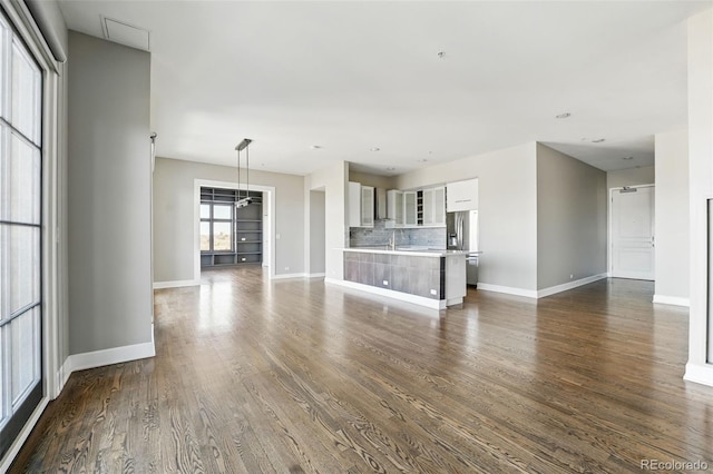 unfurnished living room featuring dark wood-style floors and baseboards