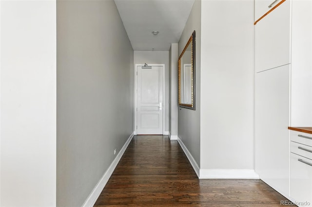 corridor with baseboards and dark wood-style flooring