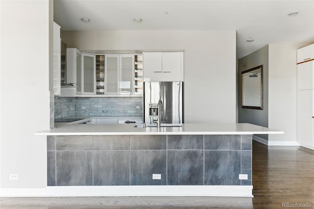 kitchen featuring backsplash, glass insert cabinets, black electric stovetop, stainless steel fridge with ice dispenser, and white cabinets