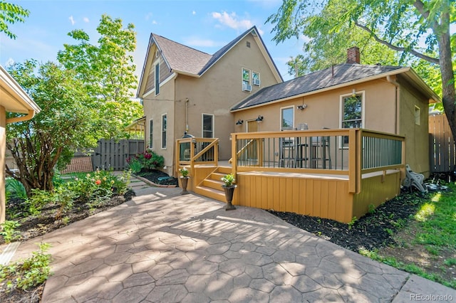 3039 W 22nd Ave, Denver, CO 80211 - rear view of house featuring stucco siding, a patio, a deck, a chimney, and a shingled roof