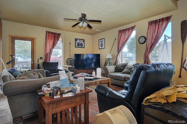 living room featuring a textured ceiling and ceiling fan