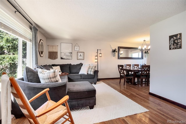 living room featuring a textured ceiling, a chandelier, and hardwood / wood-style floors