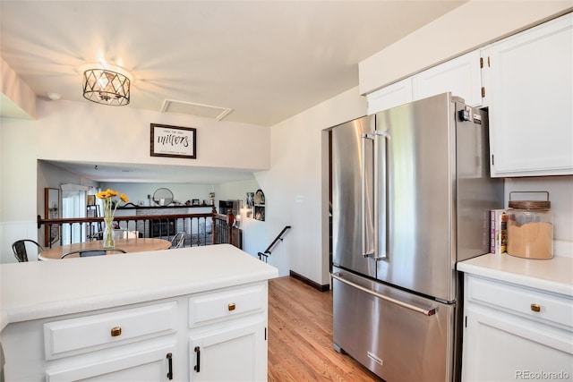 kitchen with white cabinetry, high end refrigerator, and light wood-type flooring