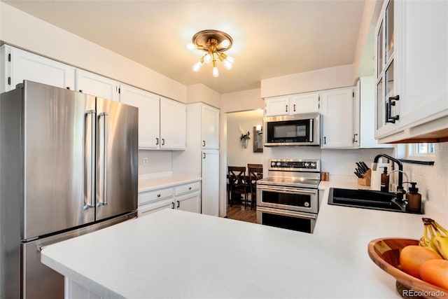 kitchen with stainless steel appliances, sink, and white cabinets