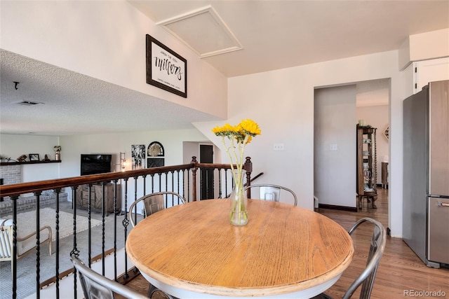 dining room with a textured ceiling and light wood-type flooring