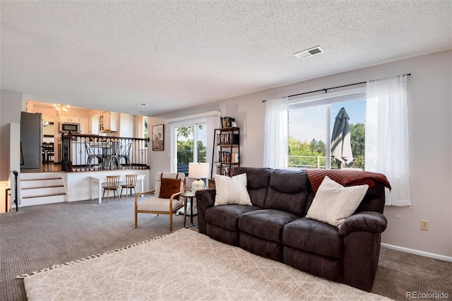 carpeted living room with a textured ceiling and plenty of natural light